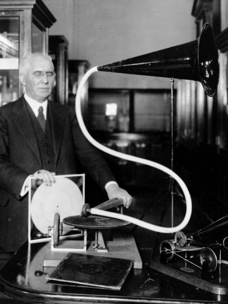 Emile Berliner en 1920 mostrando el primer modelo de su fonógrado de disco plano del año 1887